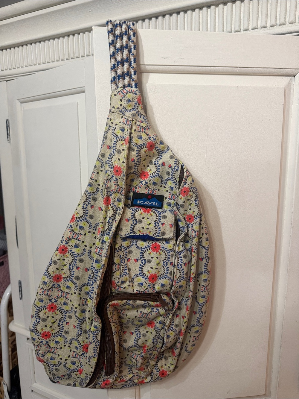Kavu cream floral crossbody sling with red and blue accents